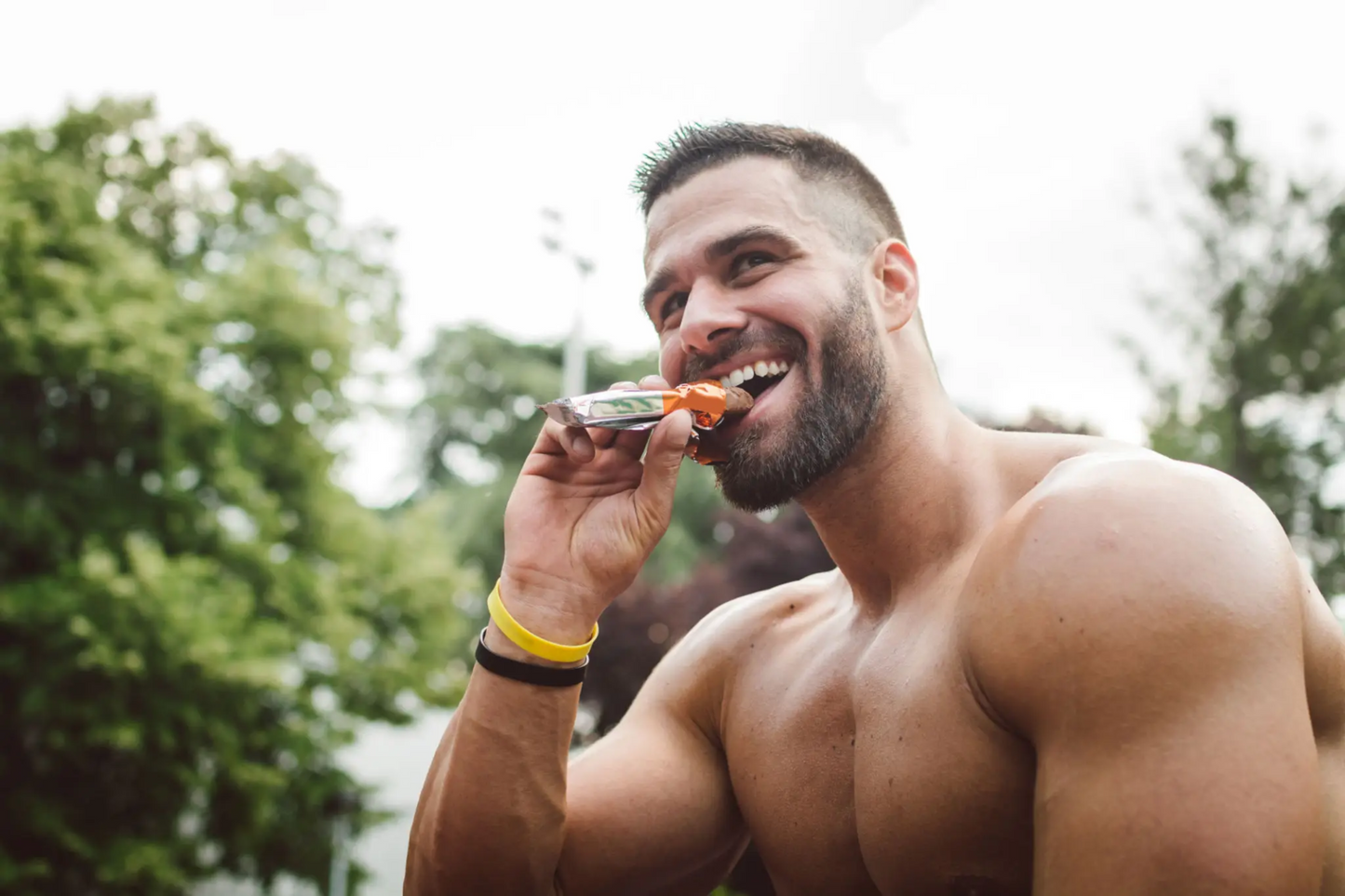 Muscular man enjoying a snack outdoors, highlighting tadalafil benefits for improved blood flow, muscle recovery, endurance, and pre-workout performance as part of a fitness and health routine