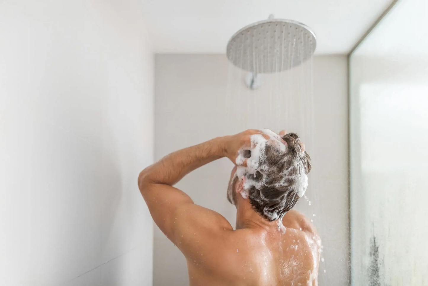 Man washing his hair with best shampoo for hair thinning 2025, promoting hair regrowth and scalp health using Fortify RX Shampoo with finasteride, minoxidil, and progesterone for effective treatment of thinning hair.