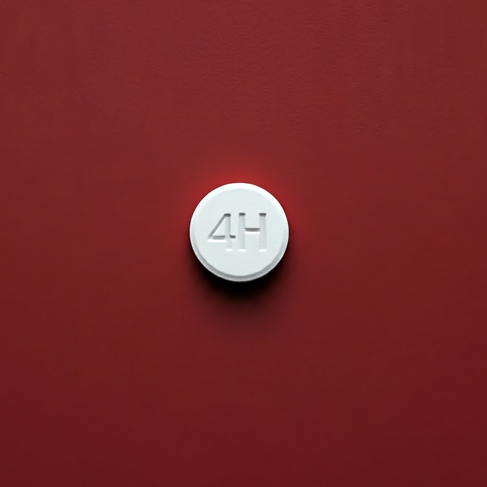 Circular white pill marked '4H' on a red background, representing a combination of Finasteride, Minoxidil, and Dutasteride for hair regrowth and male pattern baldness treatment.